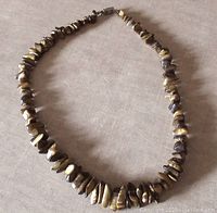 Full view of tiger's eye chip bead necklace laid out to show length and overall condition.