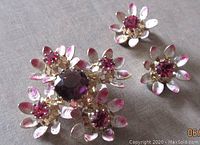 Brooch and earrings displayed with visible pink-tipped petals and multi-prong set rhinestones