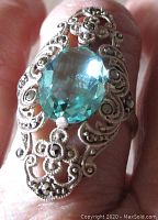 Close-up photo showing front top view of the ring highlighting the aqua blue faceted oval stone and detailed marcasite open work design