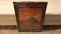 Full view of the framed and shrink-wrapped vintage poster showing the artwork of Le Mont Saint Michel with text 'Chemins de Fer de l'Etat'