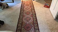 Full-length view of narrow runner rug laid on carpet