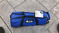 Closed blue carrying bag labeled 'Super Z'. Bag has black handles and straps, and includes a tag with product info.