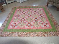 Full view of the quilt laid out on floor showing the patchwork design and borders.