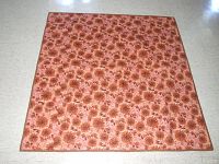 Full view of floral patterned side of the quilt showing brown chrysanthemum flowers on pink background