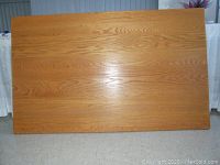 Top surface of oak dining table showing wood grain and scratches
