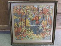 Framed print of Tom Thomson's artwork 'The Pool' in autumn featuring colorful trees and water, measuring 20x20 inches.