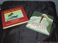 Both books placed on black fabric, showing fronts of covers.