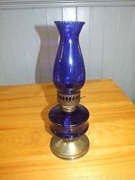 Front view of vintage blue glass oil lamp showing flared chimney and metal base