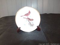 Front of the small round ceramic plate showing two cardinals painted by Glen Loates on a branch.