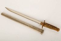 Full dagger and scabbard laid flat on white background