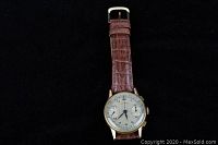 Gold-tone round wristwatch with brown leather strap front view