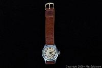 Full view of Elgin watch face and leather strap on black background