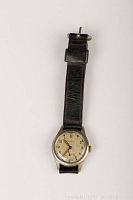 Full top view of the wristwatch with black leather strap, showing the dial and overall watch condition.