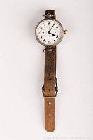 Full front view of Chronographe Escasany wristwatch showing silver case and aged brown leather strap