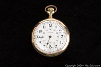 Open-face view showing white enamel dial with Arabic numerals, minute track, 24-hour inner track, subsidiary seconds dial and gold crown