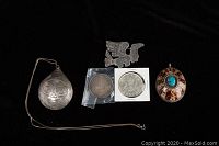 Photo showing two Canadian silver dollar coins from 1935 and 1939, a Native American sterling silver bird brooch, a sterling stamped tear drop pendant, chain, and oval turquoise pendant.