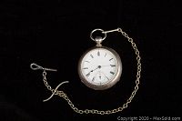 Front view of Waltham pocket watch dial with Roman numerals and seconds subdial, attached to metal chain and key.