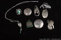 Overview of nine silver Native American–style items on black background