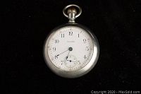 Front view of the Waltham pocket watch showing the white dial with black Arabic numerals and black hands, including the small seconds subdial at 6 o'clock.