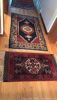 Both rugs laid out on hardwood floor, larger at rear and smaller at front