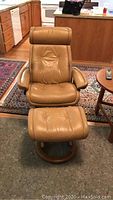 Front view of butterscotch Stressless leather recliner chair and ottoman on wood bases
