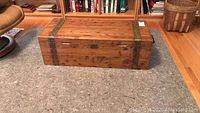 Front view of antique cedar chest showing brass riveted strap details and top surface