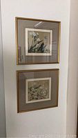 Pair of framed hand-painted silk fabric art pieces hung vertically on a white wall.