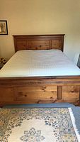 Front view of assembled queen bed with solid wood headboard and footboard