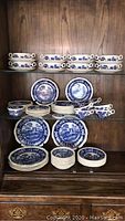 Full set arranged on shelves showing plates, bowls, cups and saucers