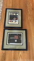 Both framed prints laid on hardwood floor