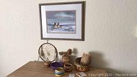 Framed watercolor painting with Native American style baskets displayed below on a table.