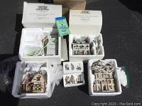 Overview of buildings and figurines in original styrofoam packaging with boxes showing Heritage Village Collection branding.