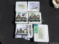 Photo showing three Thomas Kinkade Hawthorne Village miniature buildings in their original styrofoam boxes with certificates and paperwork.