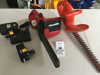 Black & Decker hedge trimmer alongside the Homelite chainsaw with two batteries and charger visible.