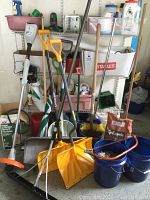 Photo showing assortment of yard care items including shovels, brooms, buckets, charcoal, and sprayer on shelving and floor.