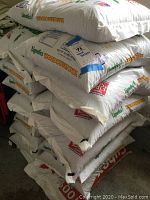 Stack of white plastic bags labeled 'Lignetics Wood Pellet Fuel' showing multiple bags stacked and ready for use.