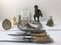 Full lot arranged on white surface showing all items including stag horn carving sets, brass bell, silver plate tray and candle holder, knight figurine, mushroom object, framed photo, and smaller bell.