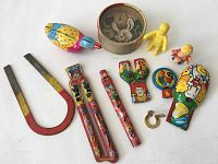 Overview of the 11 piece lot showing all toys including tin wind-ups, plastic figurines, horseshoes, and small ring toy