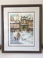 Full view of framed limited edition art print showing snowy street scene with Victorian buildings and figures walking.