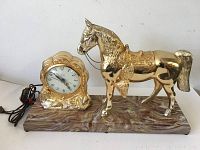 Full view of the vintage United electric clock and gold-tone horse mounted on marbled base