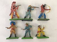 Six vintage metal toy figures with detailed paintwork, including cowboys and Native Americans on green bases