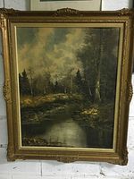 Full view of the large framed landscape print, showing the ornate gold frame and the overall forest river scene.