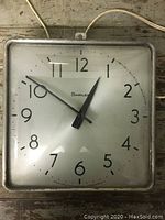 Front view of the square vintage Simplex wall clock showing white dial, black numbers and hands, and metal frame.