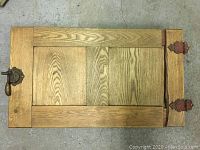 Full view of the wooden antique icebox door showing the wood grain and overall construction.
