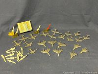 All airplane and missile toys laid out with storage box in background