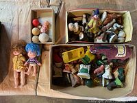 Top view of lots of vintage toys and figurines spread in cardboard boxes and on surface