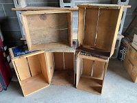 Five vintage wooden crates arranged to show interior and structural condition, made of natural wood with some label pieces visible.