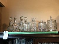 All six glass pieces displayed in a row on a shelf