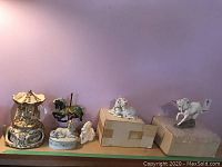 Wide view showing carousel music box and unicorn figurines on a shelf against purple wall