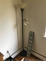 Photo of bronze tone 2-light floor lamp positioned in corner of room near a window, showing the full lamp with main frosted glass shade on top and smaller adjustable clear glass shade below.